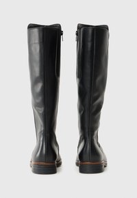 Bottes noires en cuir jusqu'au genou avec une texture lisse, fermeture éclair et détails cousus au niveau du talon. Design à bout rond.