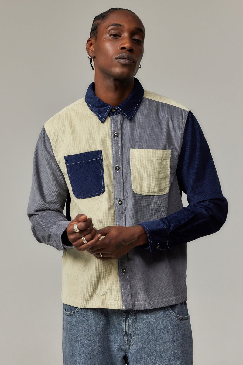 Knappskjorte med et lappe-desig i grått, marineblått og kremfarge. Laget av kordfløyel med to frontlommer og krage.