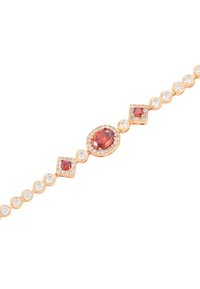Bracciale in oro rosa che presenta gemme rosse e cristalli trasparenti, alternando forme quadrate e tonde lungo una banda collegata.