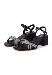 Schwarze Sandalen mit Blockabsatz und überkreuzten glitzernden Riemchen, aus glattem Leder, mit quadratischer Zehenpartie und Schnalle am Knöchel.