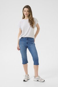 Ljusgrå kortärmad t-shirt i kombination med medelhöga, cropped blåjeans. Modellen bär grå och vita sneakers. Enkel, avslappnad stil.