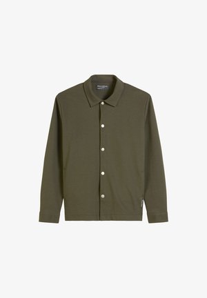 Oliwkowa koszula z długim rękawem, zapinana na guziki z metalowymi elementami w srebrnym odcieniu, klasyczny kołnierzyk, miękka tkanina i prosty dół. Posiada kieszenie boczne.