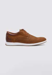 Zapatos de gamuza marrón con un acento de cuero suave, punta redonda y suela de goma blanca. Presenta textura perforada y diseño de cordones con seis ojales.
