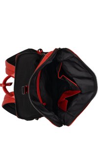 Rode leren rugzak met een zwarte binnenkant. Ritsafsluiting en meerdere vakken, waaronder een ritsvak en twee open secties.