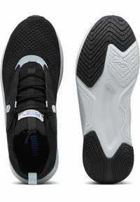 Svarta träningsskor med ett nätöverdrag, strukturerad snörning och en vit gummiöversula med ett vågigt mönster. Varumärkeslogotyp på tungan.