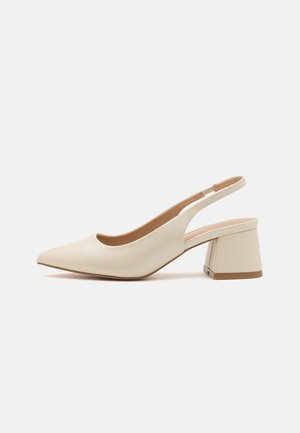 Chaussure beige à bride arrière avec bout pointu et talon bloc épais de hauteur moyenne sur fond blanc uni.