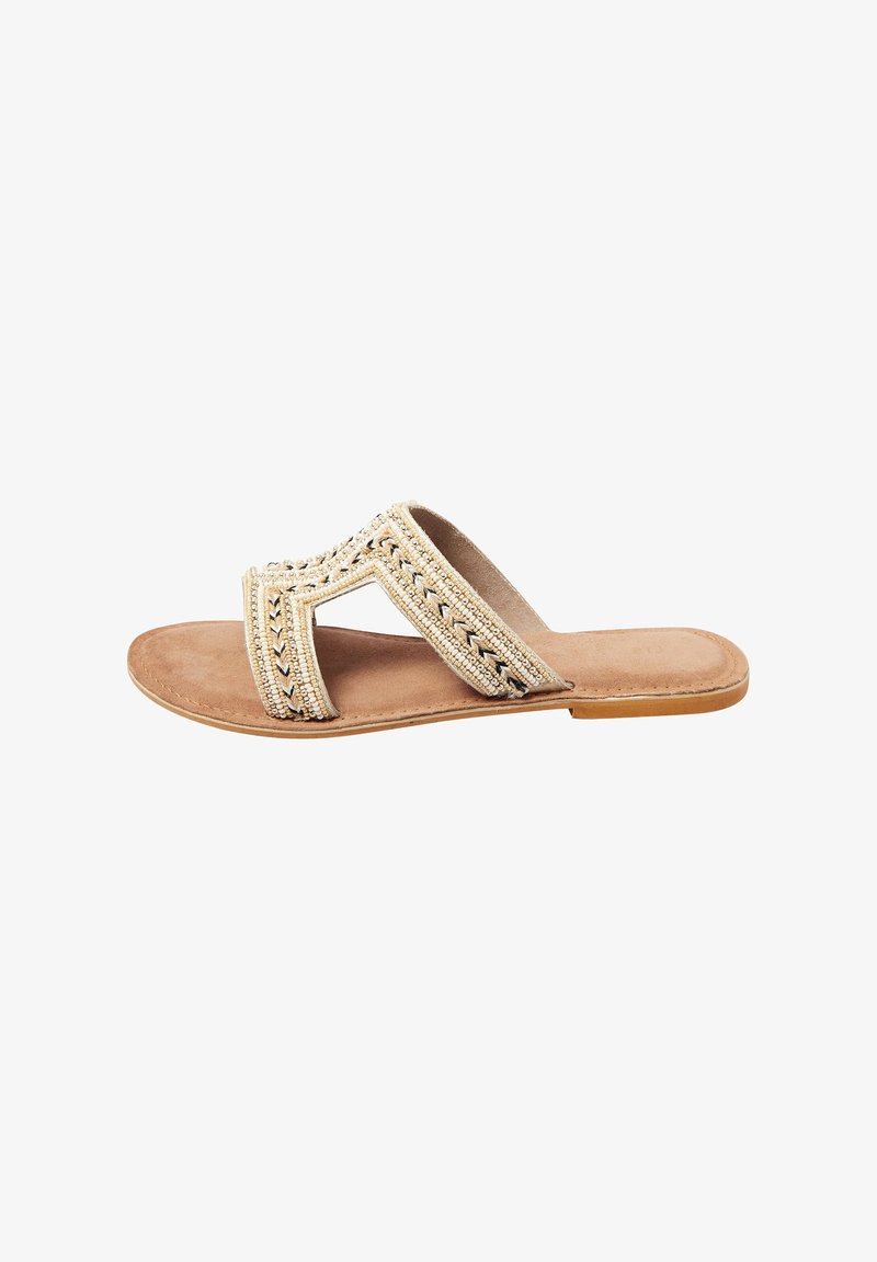 Pärlad slide-sandal med en beige tygöverdel som har ett zigzag-mönster, en platt tan-färgad sula och en komfortabel inlägg i mocka-liknande material.