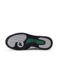 Suela de zapatilla negra y gris con un acento verde. Presenta un patrón de relieve en zigzag para proporcionar tracción y un logotipo circular en el centro.