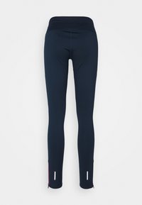 Marinblå leggings med en bred midja, slät textur, taperade ben och reflektorer vid blixtlåsen vid anklarna.