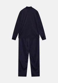 Jūras spēku krāsas koordinēts treniņtērps, izgatavots no gludas auduma, ar garām piedurknēm un apkakli, kā arī brīvām biksēm.