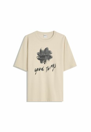 Tricou din bumbac bej cu mâneci scurte, având un design floral negru și textul "lucruri bune" sub grafic. Croială clasică.