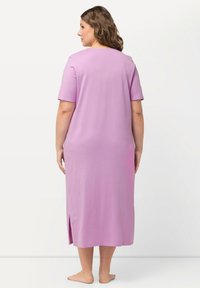 Abito lungo in cotone magenta con maniche corte, scollatura tonda e spacchi laterali, caratterizzato da una texture liscia e una vestibilità morbida.