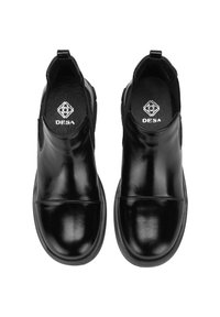 Bottines en cuir noir avec une finition brillante, panneaux élastiques sur les côtés et un design à bout rond. Possède une semelle en caoutchouc contrastante.