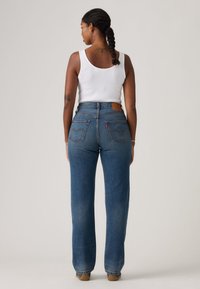 Παντελόνι τζιν σε γαλάζιο χρώμα με ψηλή μέση και άνετη εφαρμογή, με δερμάτινο πίσω ταμπελάκι και κλασικό σχεδιασμό με πέντε τσέπες.