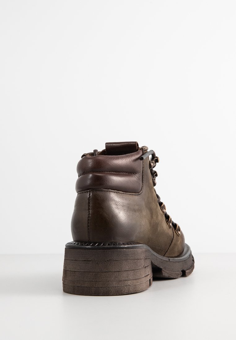 Brązowe skórzane buty trekkingowe z zaokrąglonym noskiem, wyściełanym kołnierzem i metalowymi oczkami. Gruba, teksturowana gumowa podeszwa z rowkami zapewniającymi przyczepność.