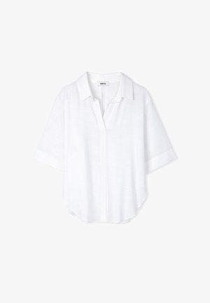Camicia bianca a maniche corte con chiusura a bottoni, dalla texture morbida e con orlo arrotondato. Presenta un colletto classico e una vestibilità rilassata.