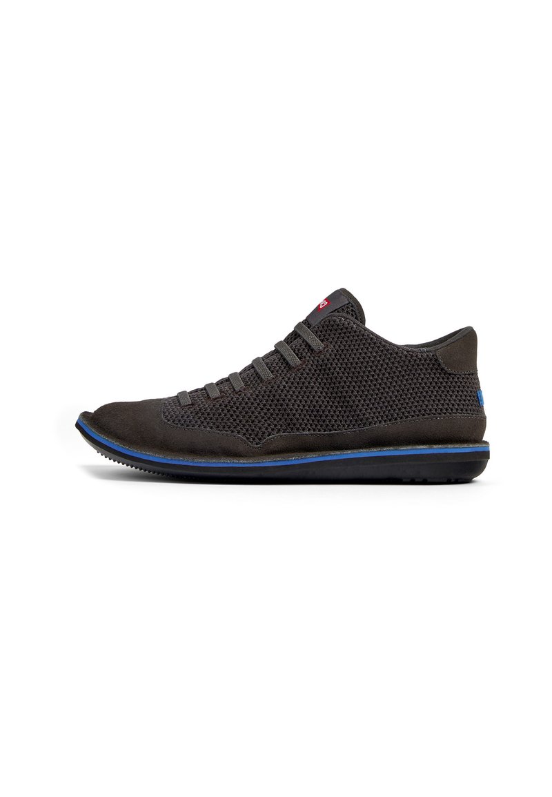 Donkergrijze sneaker met een bovenwerk van mesh, suede accenten, platte veters en een blauwe zoolaccent. Gestroomlijnde vorm met subtiele textuurdetails.