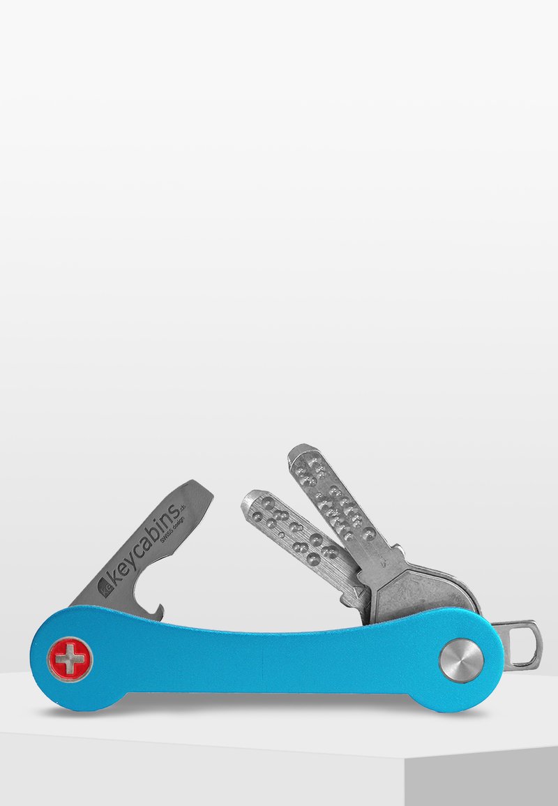 Blå metallnyckelhållare med en schweizisk korslogotyp, har två silvernycklar och en fickklipp för enkel fästning.