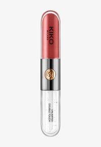 Producto labial de doble extremo con tono rosa brillante en la parte superior y brillo transparente con burbujas en la parte inferior, banda plateada con logo dorado en el centro.