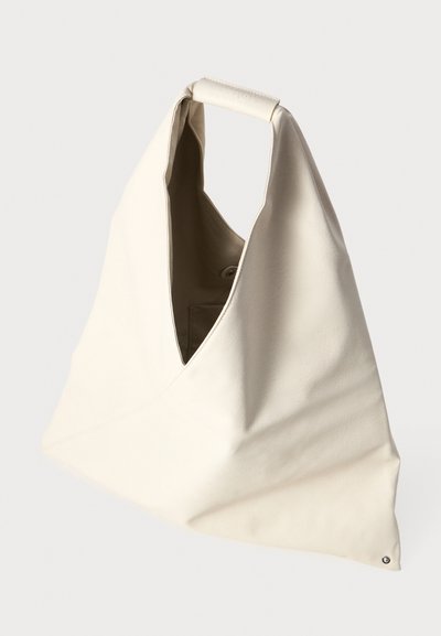 Saco de couro bege com forma triangular, topo aberto e alça curta. Apresenta uma textura suave e um design minimalista.