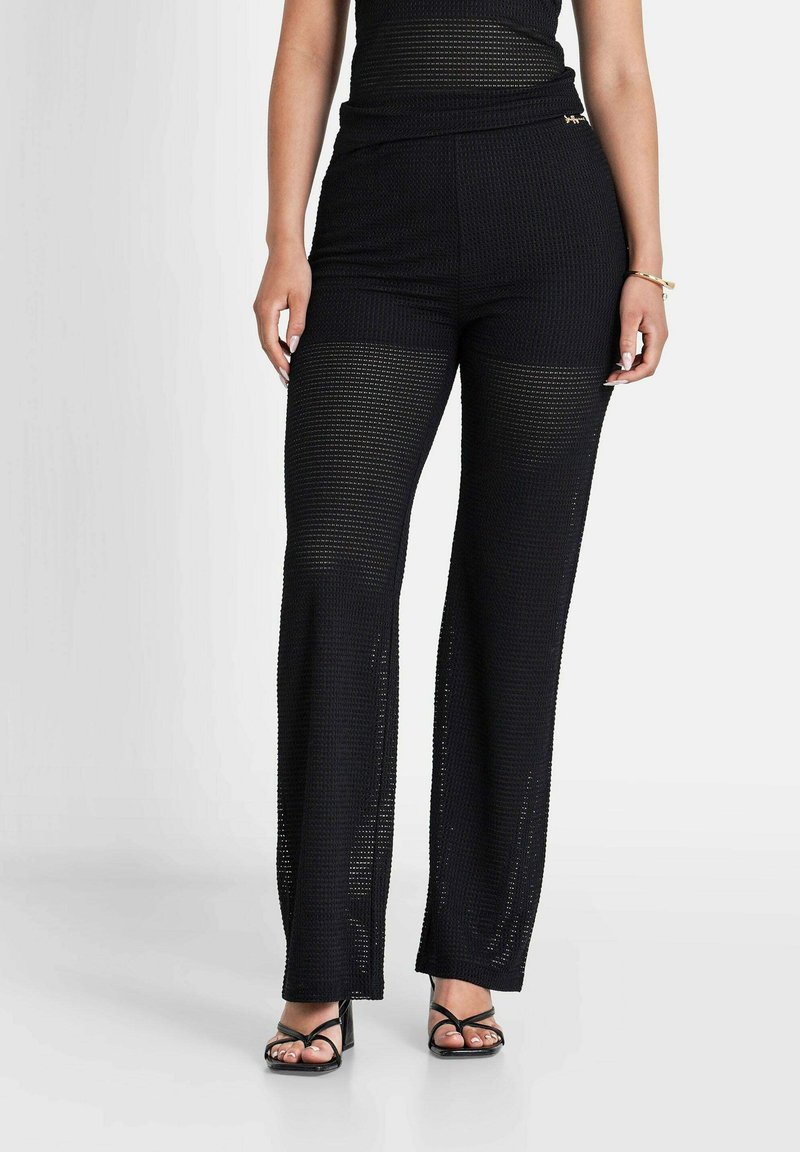 Zwarte gebreide wijd-uitlopende broek met een gestructureerd meshpatroon, hoge taille en een decoratieve gouden accenten op de tailleband.