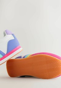 Krāsains sporta apavu pāris ar materiālu maisījumu purpursarkanā, rozā un zilā krāsā. Tam ir teksturēta gumijas zole un daudzslāņu dizaina elementi.