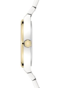 Orologio da polso in metallo argento e oro con un profilo slanciato, cassa tonda, corona prominente e una finitura lucida sui bordi del bracciale e della cassa.