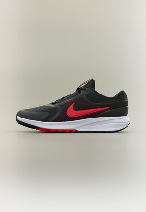 Čierna a červená bežecká obuv Nike s bielou podrážkou, viditeľným vzduchovým tlmením a červeným logom Swoosh na boku, zobrazená z profilu.