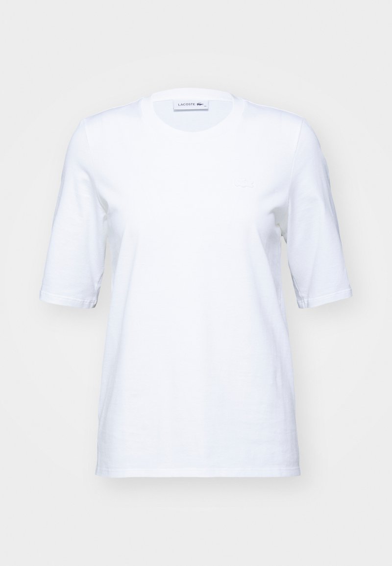 Biała bawełniana koszulka z krótkim rękawem, okrągłym dekoltem i subtelnym haftowanym logo na piersi. Gładka tekstura, klasyczny krój.