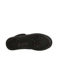 Svart sneaker-sula med cirkulära mönster och stjärnformade grepp på en vit bakgrund.