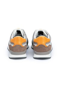 Graue und braune Wildledersneaker mit orangefarbenen Akzenten, gepolstertem Kragen, weißem Innenfutter und einer strukturierten Gummisohle. Minimalistisches Design.