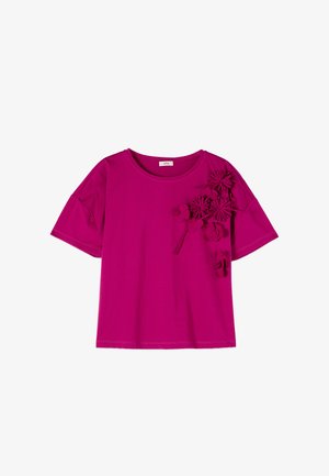 Maglietta magenta a maniche corte con scollo rotondo e decorazioni floreali 3D sulla spalla sinistra e nella zona del petto.