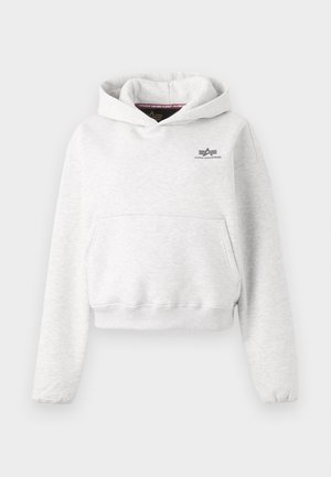 Svetlo šedý skrátený hoodie s prednou kapsou a malým čiernym logom "Alpha Industries" na hrudi.