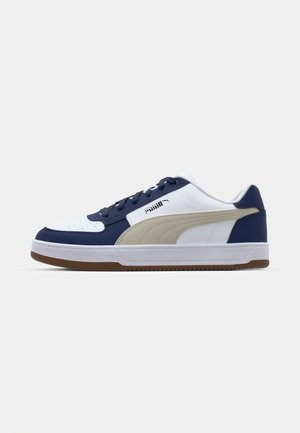 Tenis cu o bază din piele albă, accente bleumarin și panouri laterale bej. Prezintă șireturi, guler căptușit și talpă din cauciuc cu textură pentru aderență.