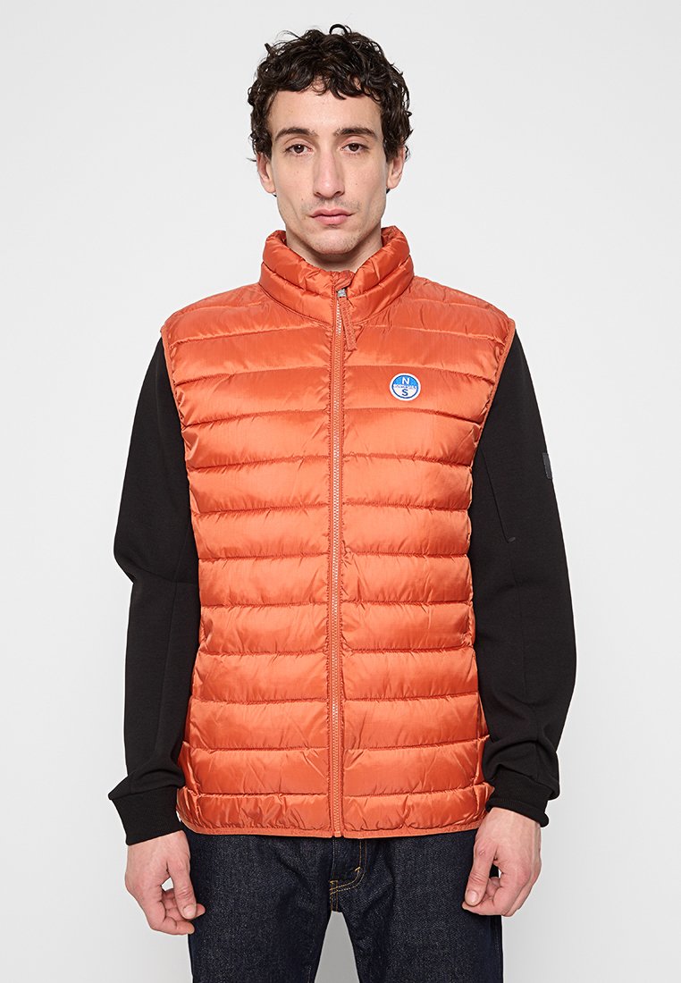 Oranger Puffer-Weste mit hohem Kragen und Reißverschluss, mit horizontalen Steppnähten und einem blauen Logopatch auf der Brust.