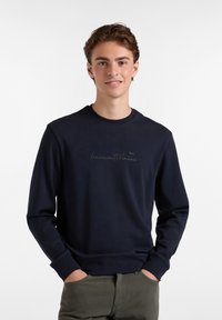 Sudadera azul marino hecha de tejido suave, con un escote redondo y mangas largas, y un discreto diseño de logo en la parte delantera.