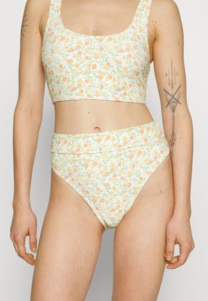 Blommönstrad bralette och högmidjad bikiniset, med en pastellfärgsschema, lätt ribbad textur och ett mjukt, elastiskt material.