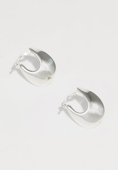 Boucles d'oreilles en argent avec une finition polie et réfléchissante, présentant une forme arrondie en goutte d'eau et un fermoir à charnière.