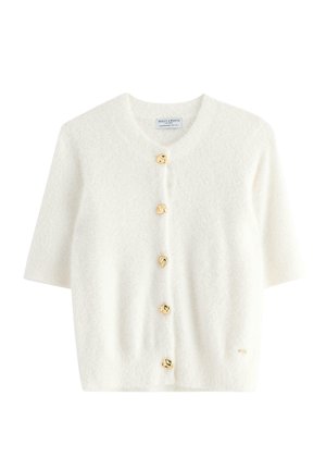 Kortärmad, vit cardigan i ett mjukt tyg med fem oregelbundna guldfärgad knappar fram, med rund hals och texturerad yta.