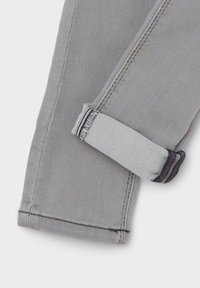Hallkapseldest hall denim kangas, millel on keeratud äär, kontrasteeriv õmblus ja sile tekstuur. Omab turvalist silmust musta niidiga.