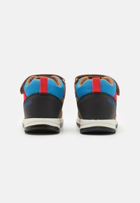 Pantofi din piele întoarsă maro și sintetic negri, cu accente albastre și roșii, dotati cu curele ajustabile și un design ușor pentru confort.
