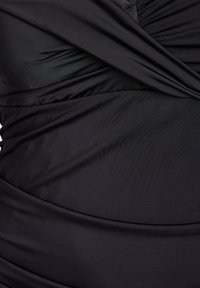 Must ujumisriiet, millel on voltidega disain ja sile kangapind. Sisaldab horisontaalset ja vertikaalset kogumist, et luua kujundav efekt.