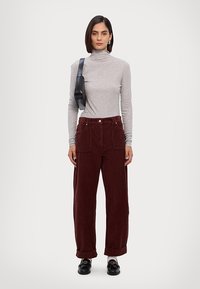 Gray turtleneck top, burgundy corduroy wide-leg pants with pockets, styled with a black crossbody bag and black loafers. Smooth textures.