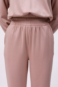 Pantalons roses à taille élastique, avec une texture douce et lisse. Dotés d'une taille froncée et de poches latérales, conçus pour le confort et la facilité.
