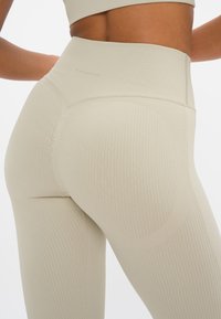 Lichte beige geribde legging met een hoge taille, met een soepele textuur en accentueerde naden voor een aansluitende look.