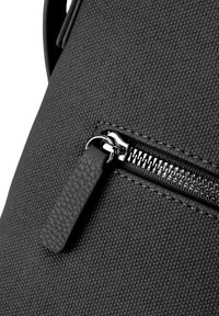 Borsa a tracolla in tessuto nero con una tasca con zip, dotata di una cerniera metallica e di un manico in pelle, che offre un design elegante e funzionale.