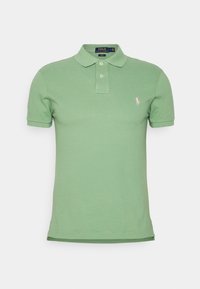 Ljusgrön polo-t-shirt i bomull, med en knäppning med tre knappar, korta ärmar och en liten broderad logotyp på vänster bröst.