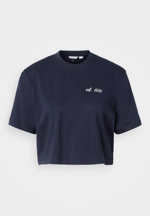 Námořnicky modré zkrácené tričko s krátkým rukávem, kulatým výstřihem a bílým nápisem "est. 1956" na levé části hrudi.