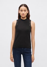 Must varrukateta topi kõrge kaelusega, mille õlgadel on hõbedased silmad ja sile, veniv kangas.