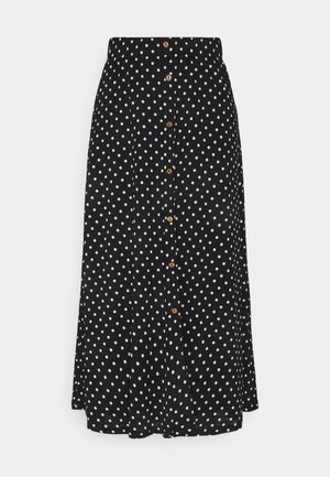 Sort nederdel med hvide prikker, knapfrontlukkede med træknapper og en glat stoftekstur. A-formet silhuet.